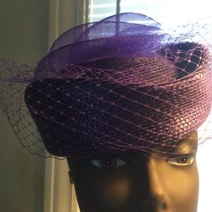 Purple pillbox style hat with face netting.